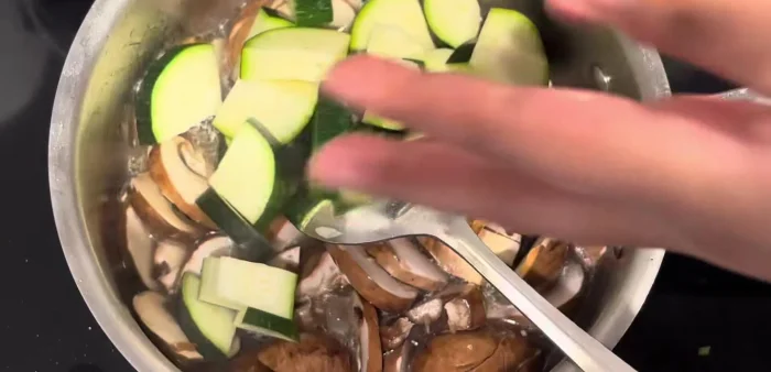 Add mushrooms and zucchini to the broth.