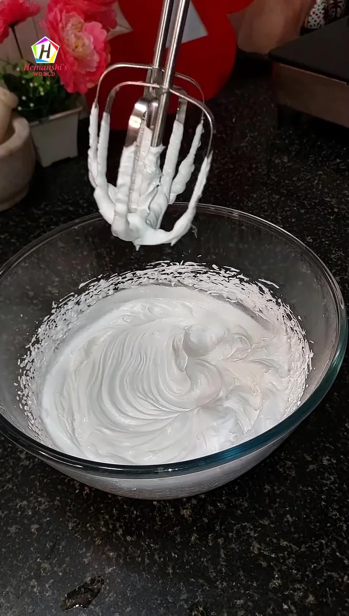 Whip the whipping cream with sugar and flavoring until stiff peaks form.