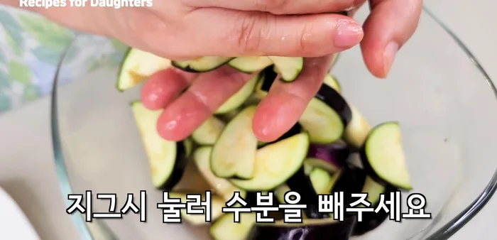 Press the pickled eggplants to remove excess water.