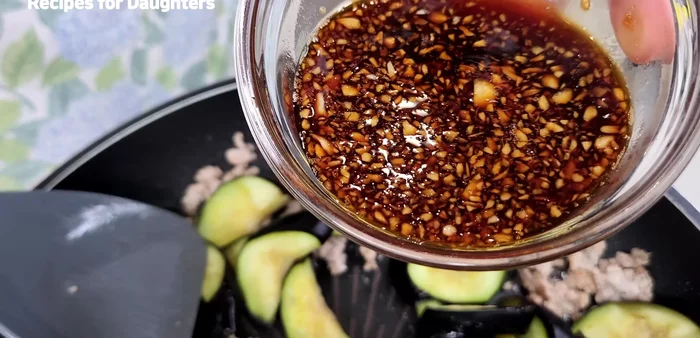 Add the pickled eggplants and seasoning sauce to the pan. Stir-fry until the eggplant is coated in the sauce.