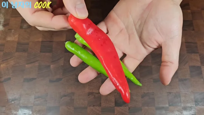 Prepare two green peppers and one red pepper. Thinly slice the Cheongyang pepper and chop the red pepper into small pieces.