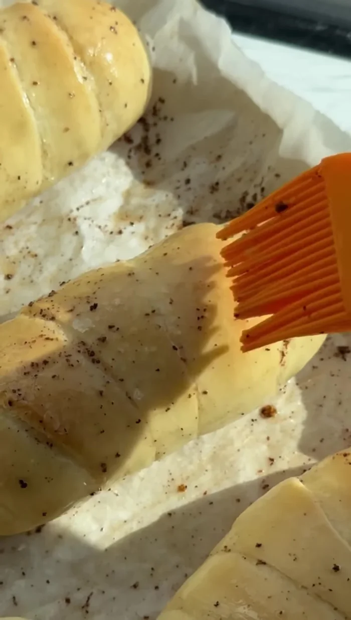 Brush the baked rolls with butter from the sheet pan.