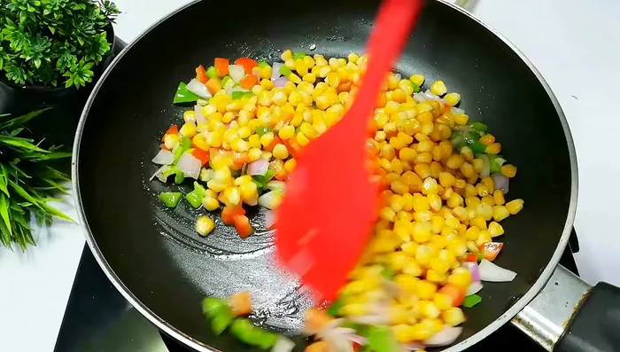 Add 1 cup of boiled corn and mix well. Add salt, 2 pinches of black pepper powder, 2-3 pinches of oregano seasoning, chili flakes, and a pinch of garam masala. Taste and adjust seasonings as needed.