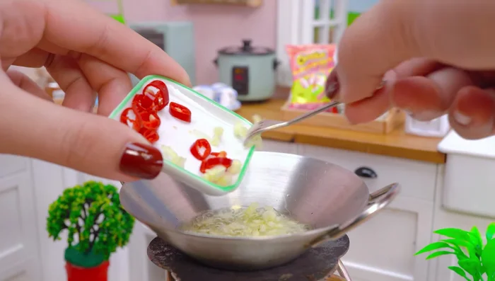 Prepare a spicy sauce with cooking oil, garlic, chili, bell pepper, paprika, salt, and black pepper.