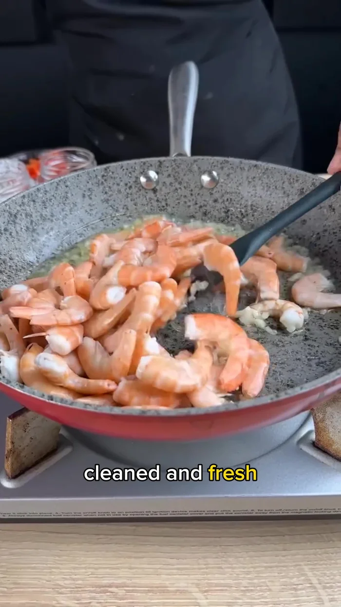 Add 1 and 1/3 lbs of cleaned shrimp to the skillet and sauté thoroughly, allowing them to absorb the garlic and oil flavor.