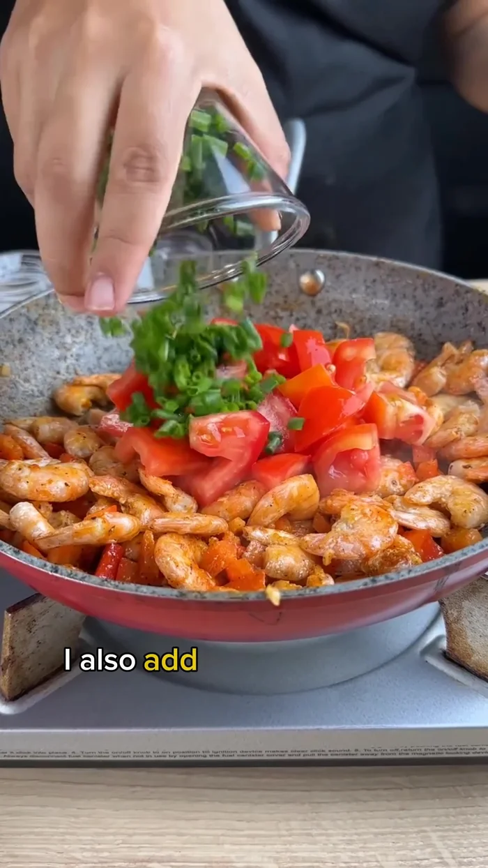 Add one large tomato (cut into chunks), chopped green onions, and 1 tablespoon of butter. Mix until the butter melts and blends well.