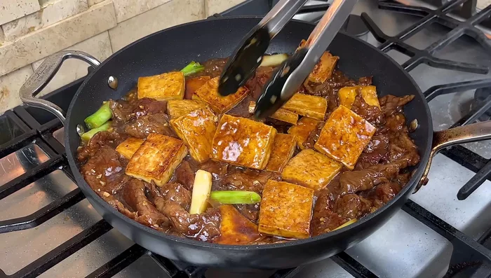 Add tofu, onion, leafy green onions, and black pepper. Toss to combine.