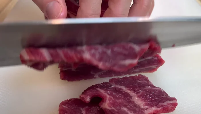 Cut beef across the grain into slices. Marinate with soy sauce, dark soy sauce, water, sugar, white pepper, baking soda, corn starch, and sesame oil.
