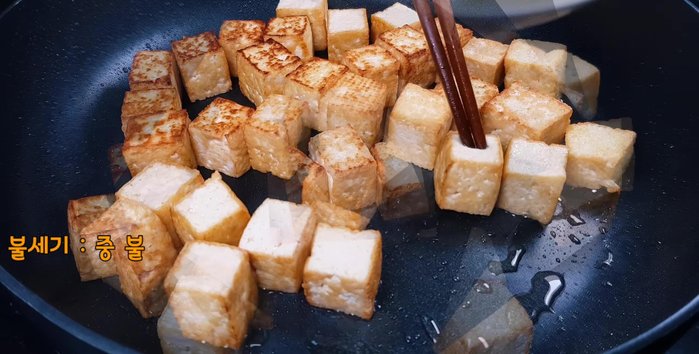 When the tofu is almost done, add the sliced onions.