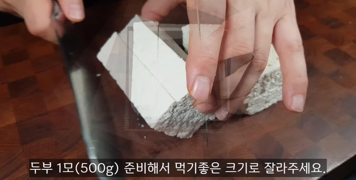 Prepare a 500g roll of fried tofu, cut into quarters, lay it on its side, cut it in half, and then cut it into quarters again to make bite-sized pieces.