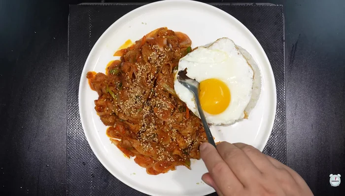 Serve the pork on rice with a fried egg and sesame seeds.