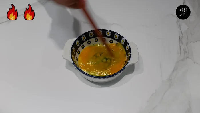 Beat an egg and pour it into the pan with the onion mixture. Lightly cook the egg.