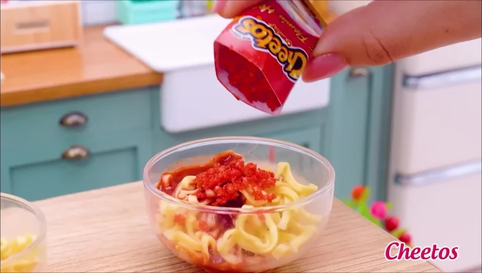Prepare the second noodle dish: Add noodles, hot sauce, chili powder, Cheetos, ghost pepper sauce, black pepper, green chili, and parsley.