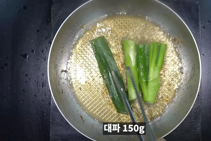 Fry green onions, ginger, onions, garlic, and whole peppers in the oil used to fry the meat.