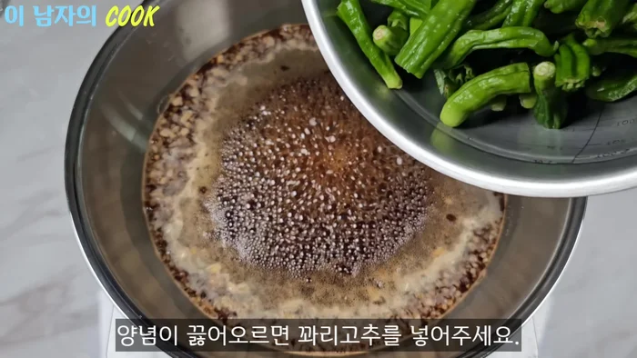 Add the prepared chili peppers once the seasoning starts bubbling.