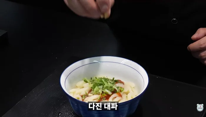 Bibim-mu-dong: Boil one frozen noodle. Sprinkle with buldak-dangkong sauce, chopped green onion, and sesame seeds.