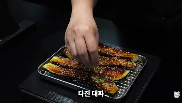Seasoned Eggplant: Spread buldak-dangkong sauce on deep-fried eggplant. Sprinkle with sesame seeds and chopped green onions.
