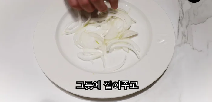 Thinly slice onion and spread on ddeokbokki (if using). Top with chopped scallions, sliced pork jowl, and seasoned sauce. Add more pepper.